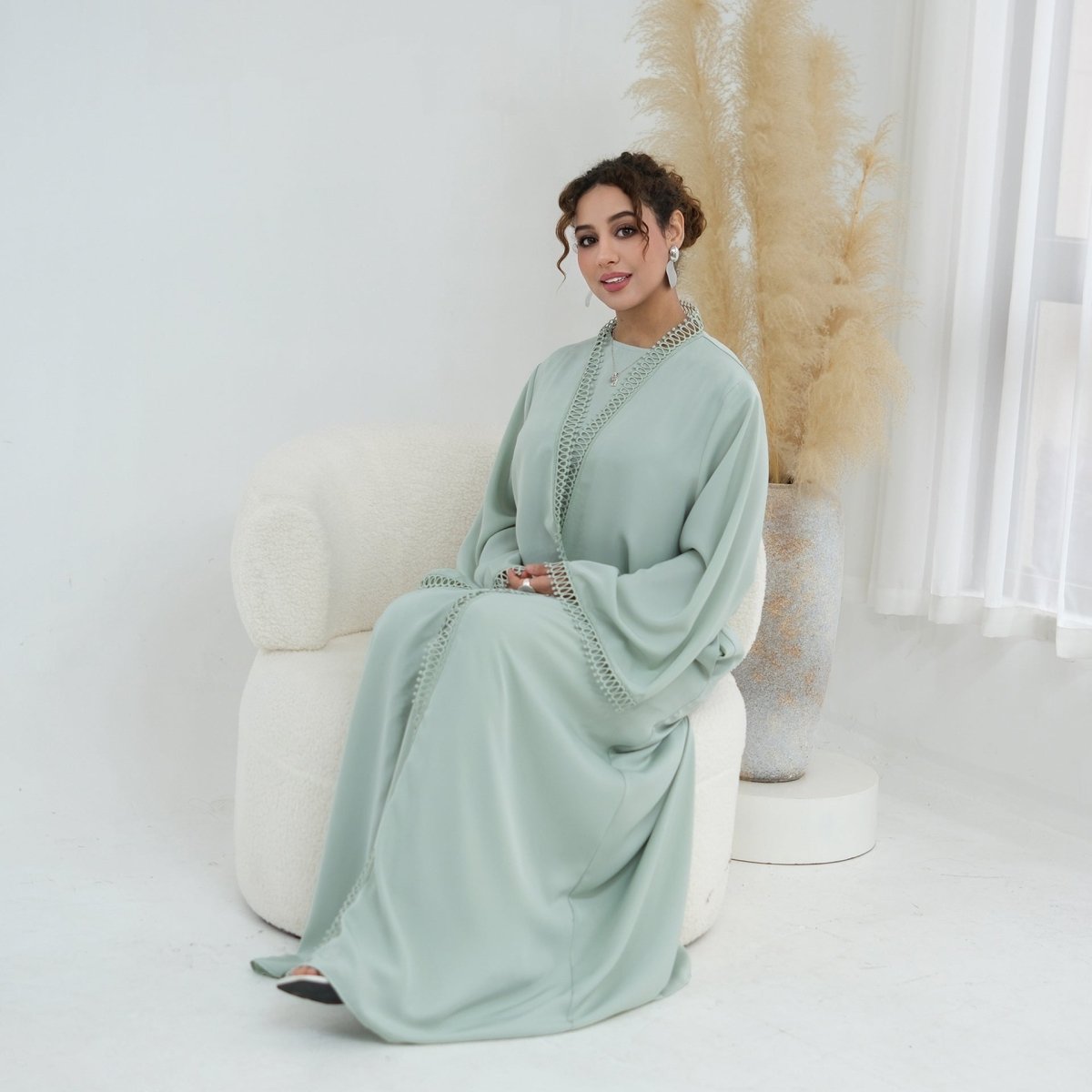 Three-quarter view of batwing sleeve drape on 3D lace open abaya