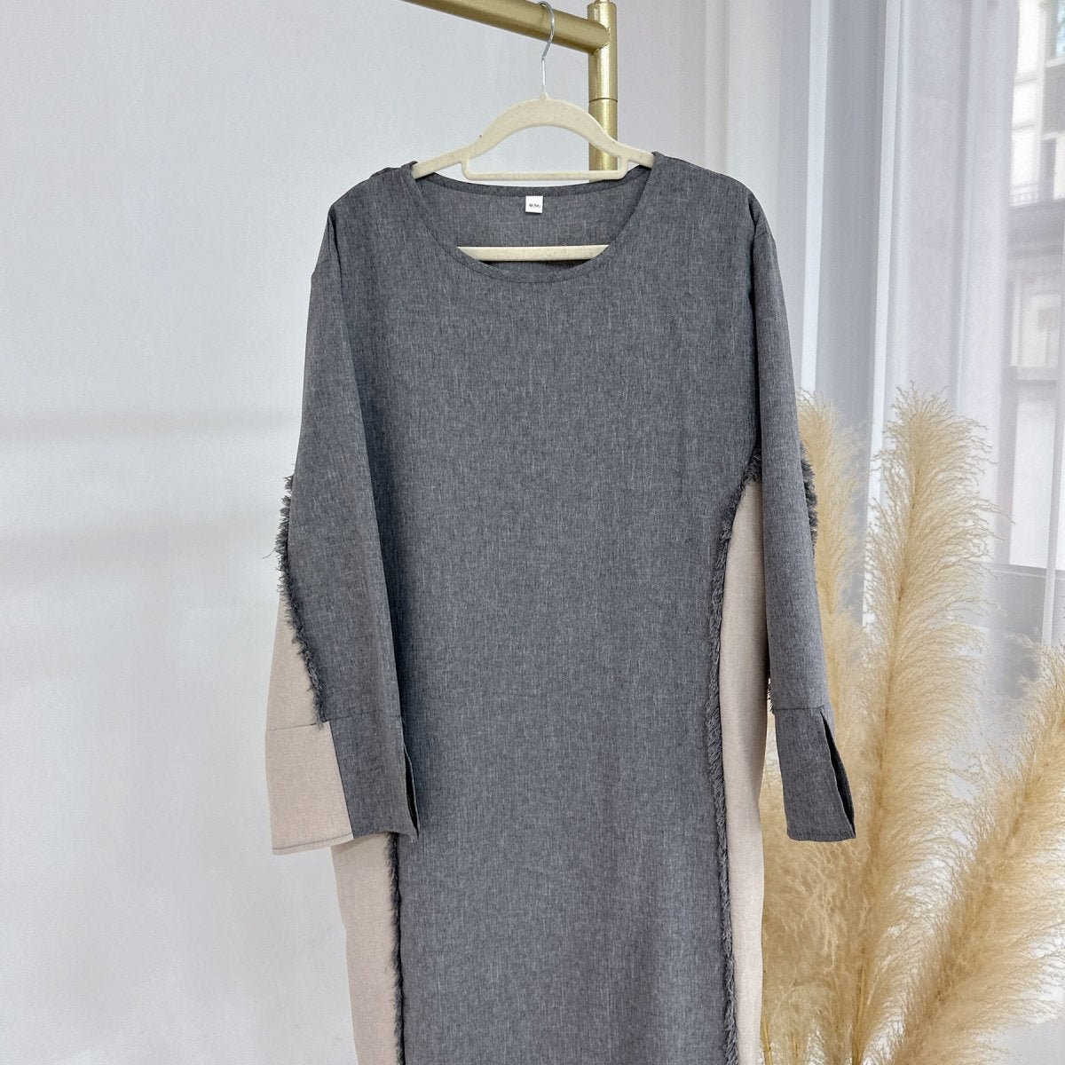 Roll-back cuff detail revealing ivory underlayer on relaxed-fit patchwork tunic