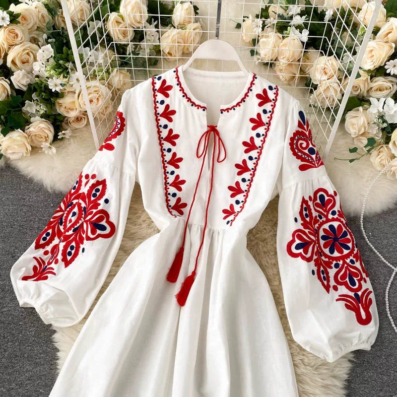 Close-up of red tassel tie cord and V-shaped embroidered neckline detail
