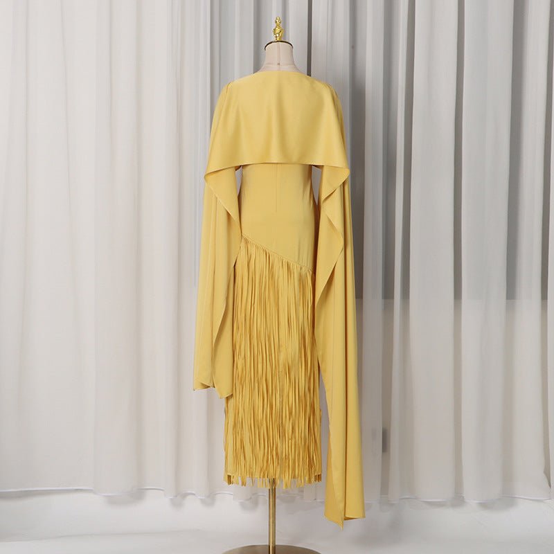 Close-up of diagonal fringe panel detail from hip to hem on golden dress