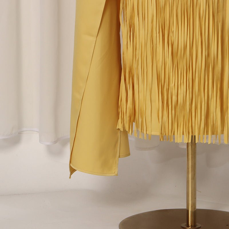 Editorial styling shot of two-piece effect cape and fitted sheath dress in gold
