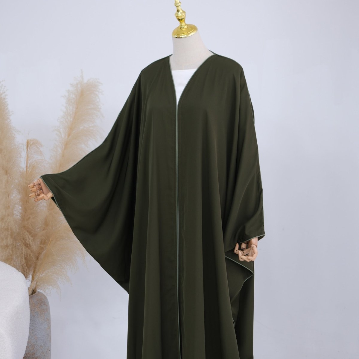 Tonal contrast piping trim detail along front panel of open abaya