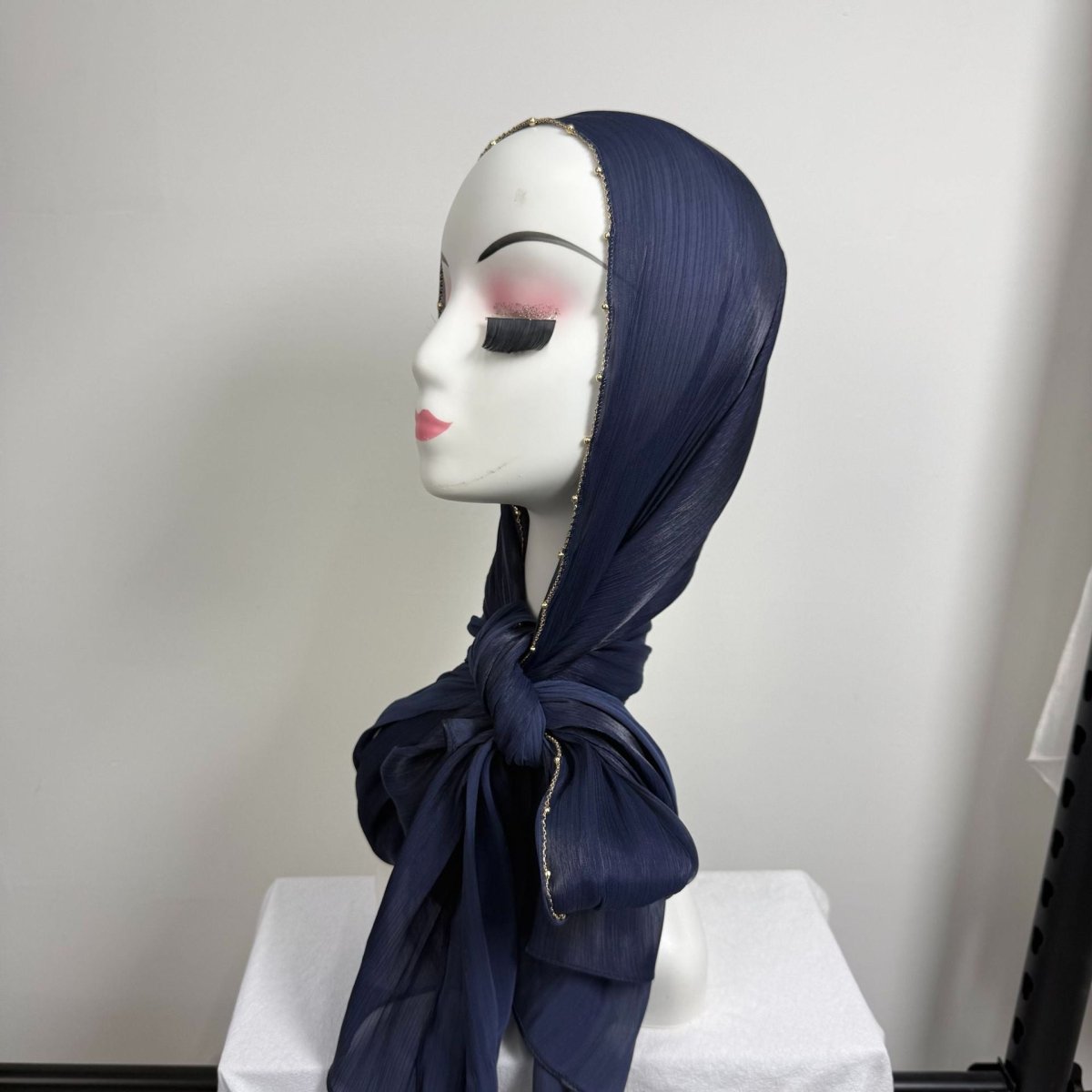 Angled view of gold chain beaded satin hijab showing drape and movement