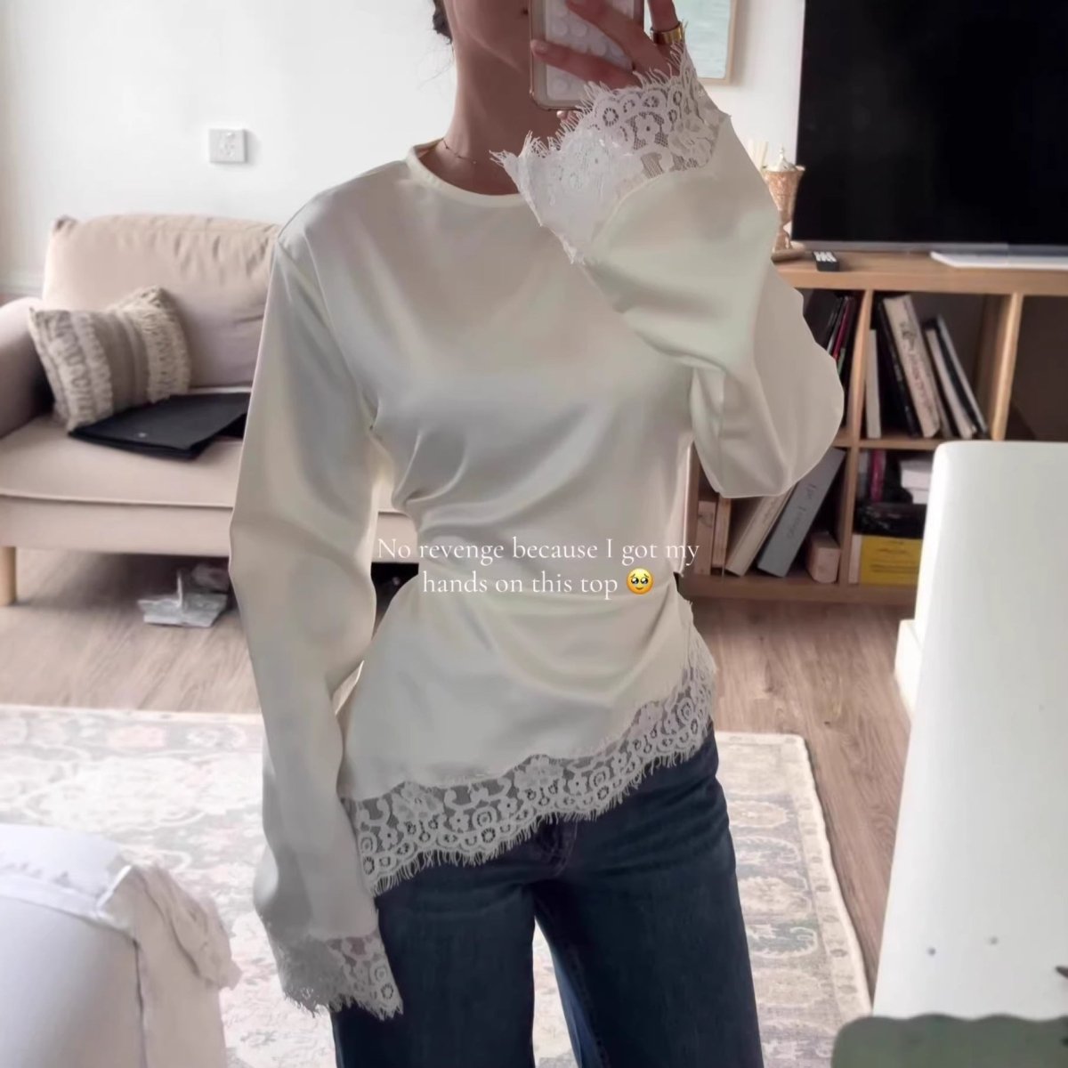 Side view of asymmetric lace top showing crew neckline and long fitted sleeves