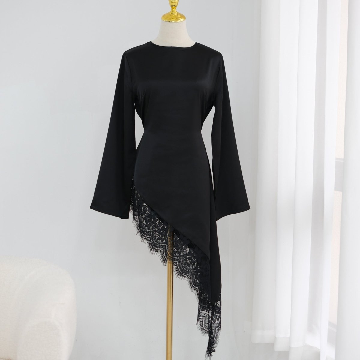 Model wearing black lace trim satin top from a side profile