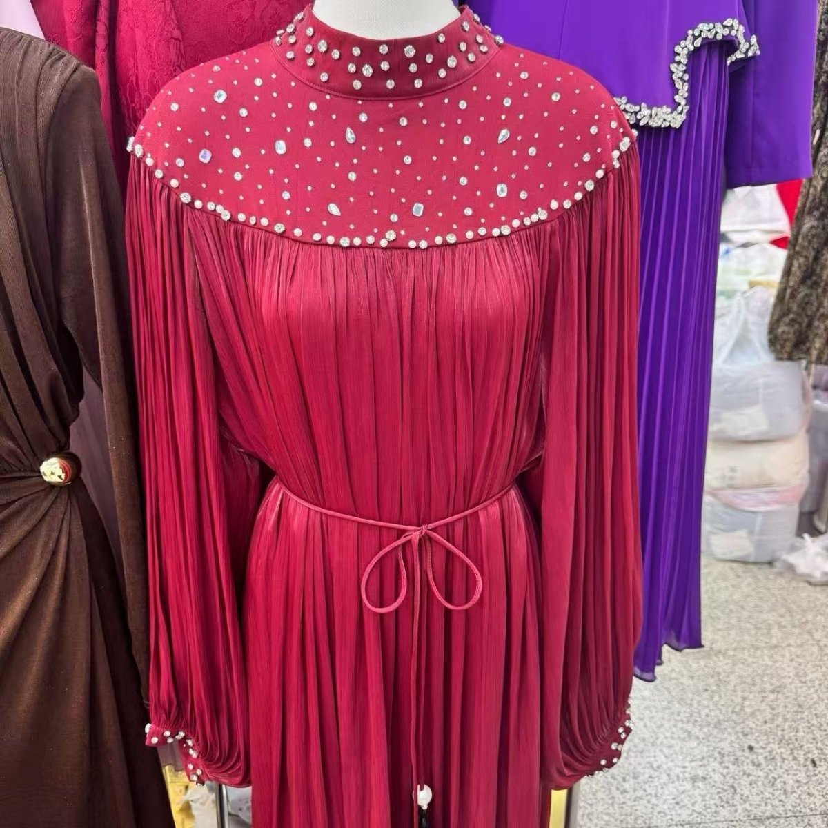 Side profile showing gathered empire waist and flowing pleated hem