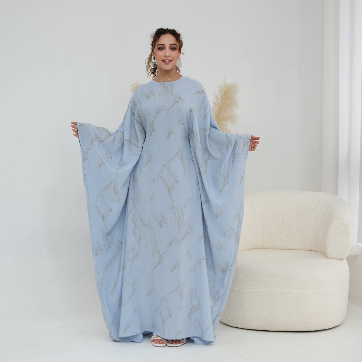 Three-quarter view of batwing sleeve abaya maxi dress in motion