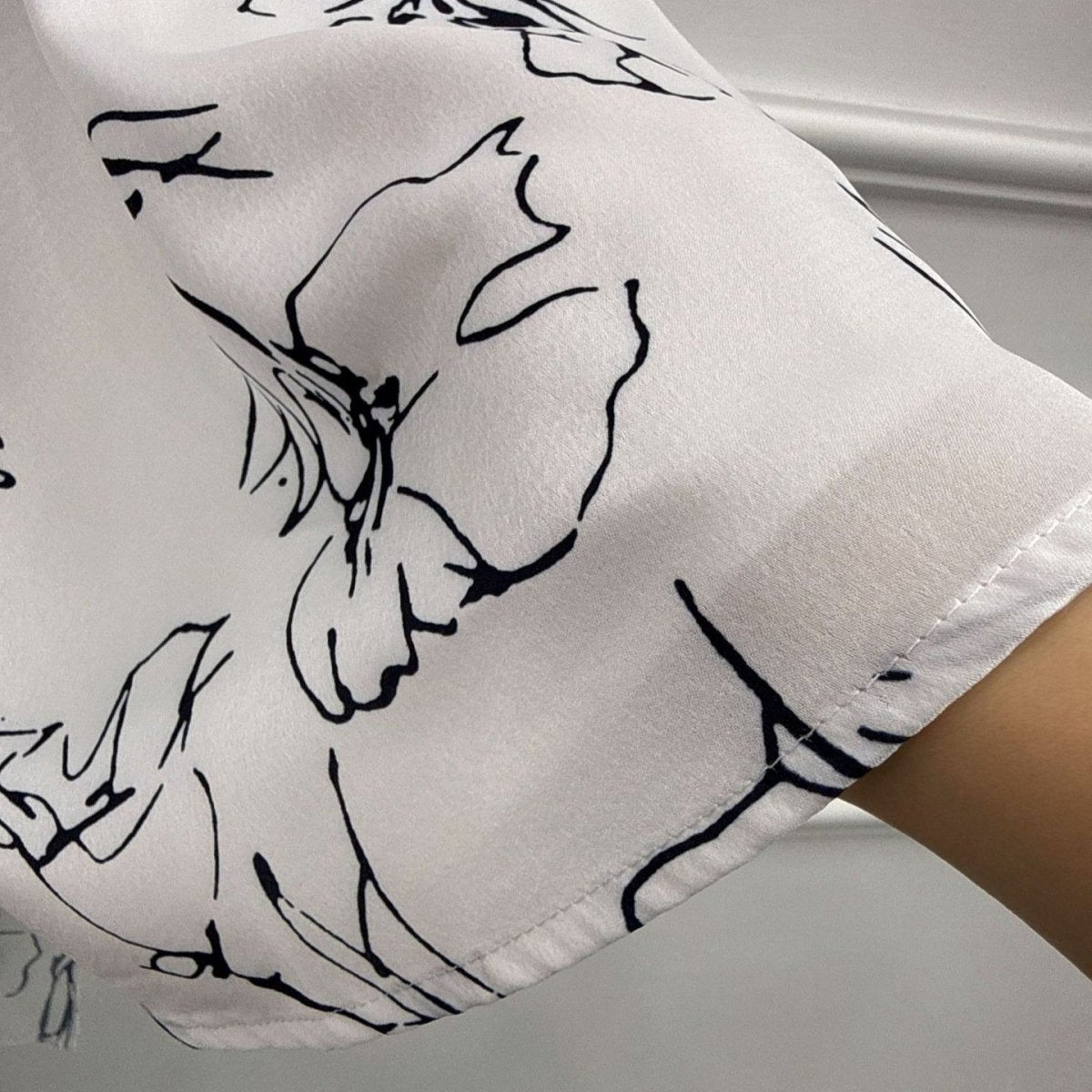 Flared sleeve movement detail on printed open abaya, showing layered cuff lining