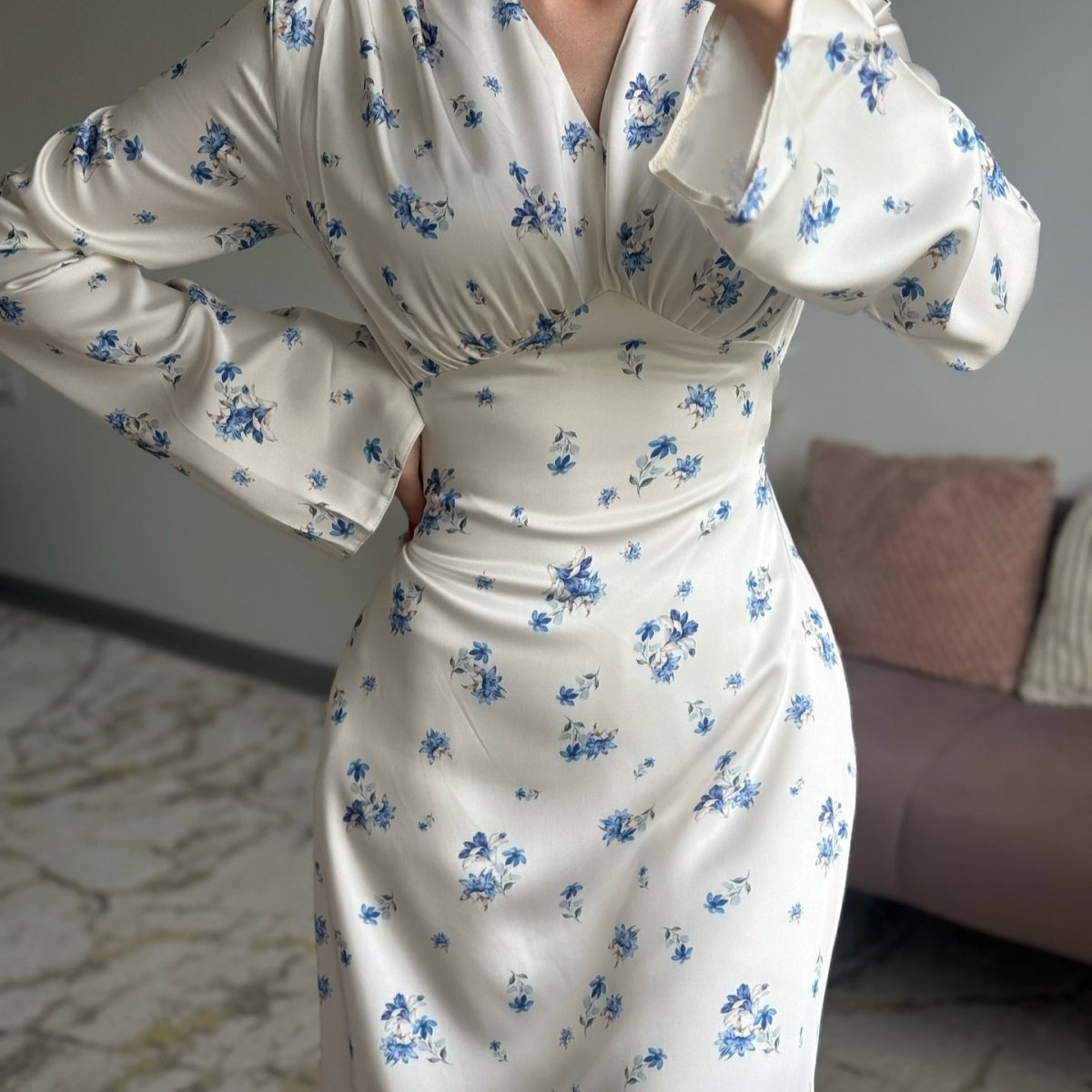 Close-up of gathered empire waist and V-neckline detail on satin floral dress