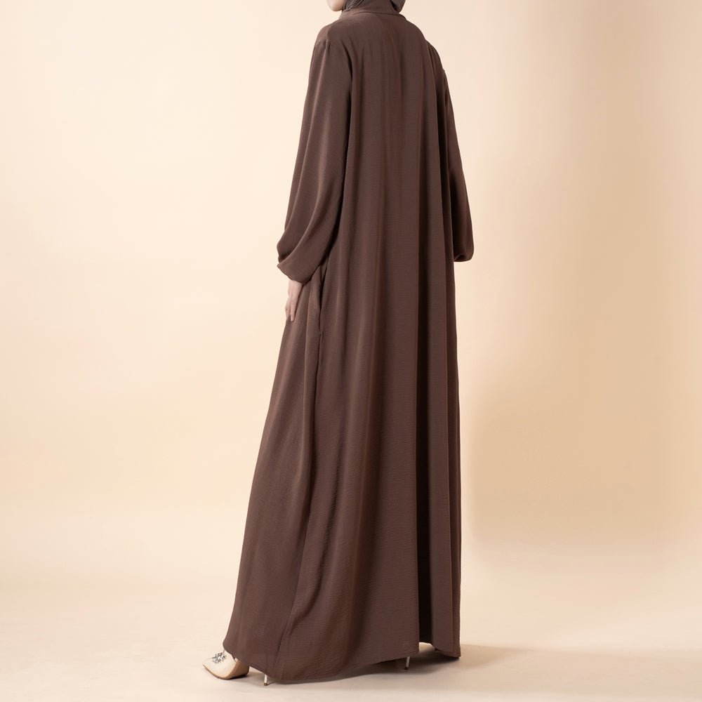 Open abaya draped loosely to show relaxed modest silhouette