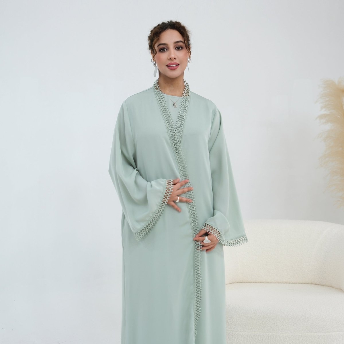 Fitted column silhouette of sleeveless inner dress worn under open abaya