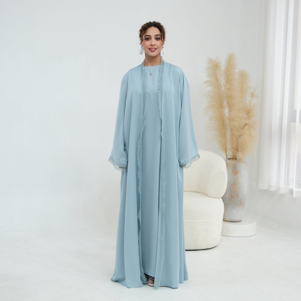 Flat lay of complete two-piece abaya and sleeveless dress set