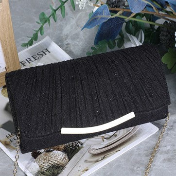 Close-up of pleated glitter fabric on evening clutch bag