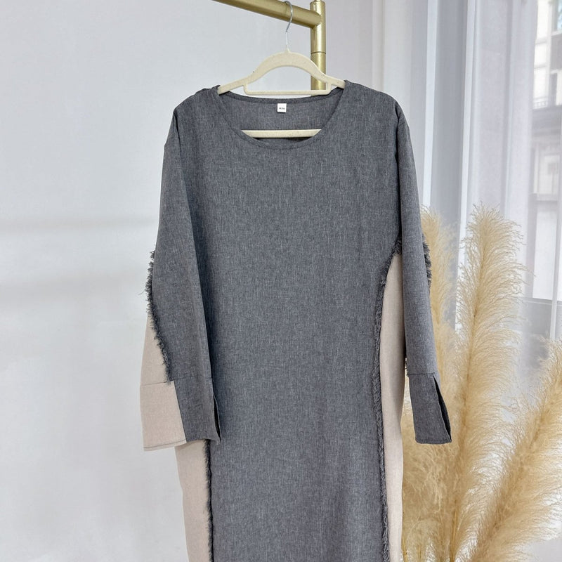 Roll-back cuff detail revealing ivory underlayer on relaxed-fit patchwork tunic