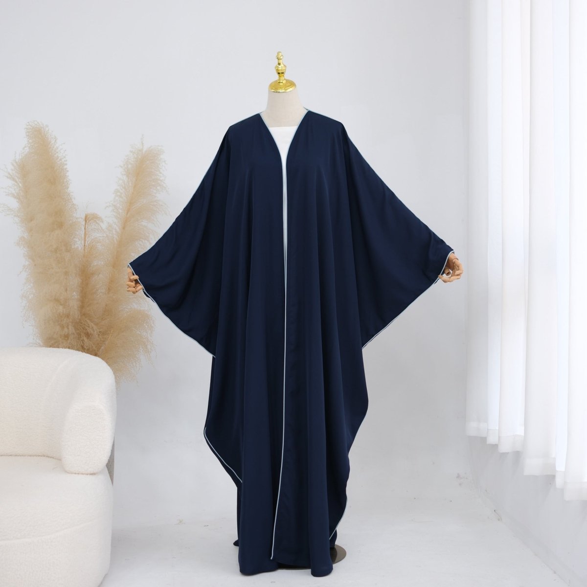 Full collection flat lay of contrast piped batwing abaya colourways