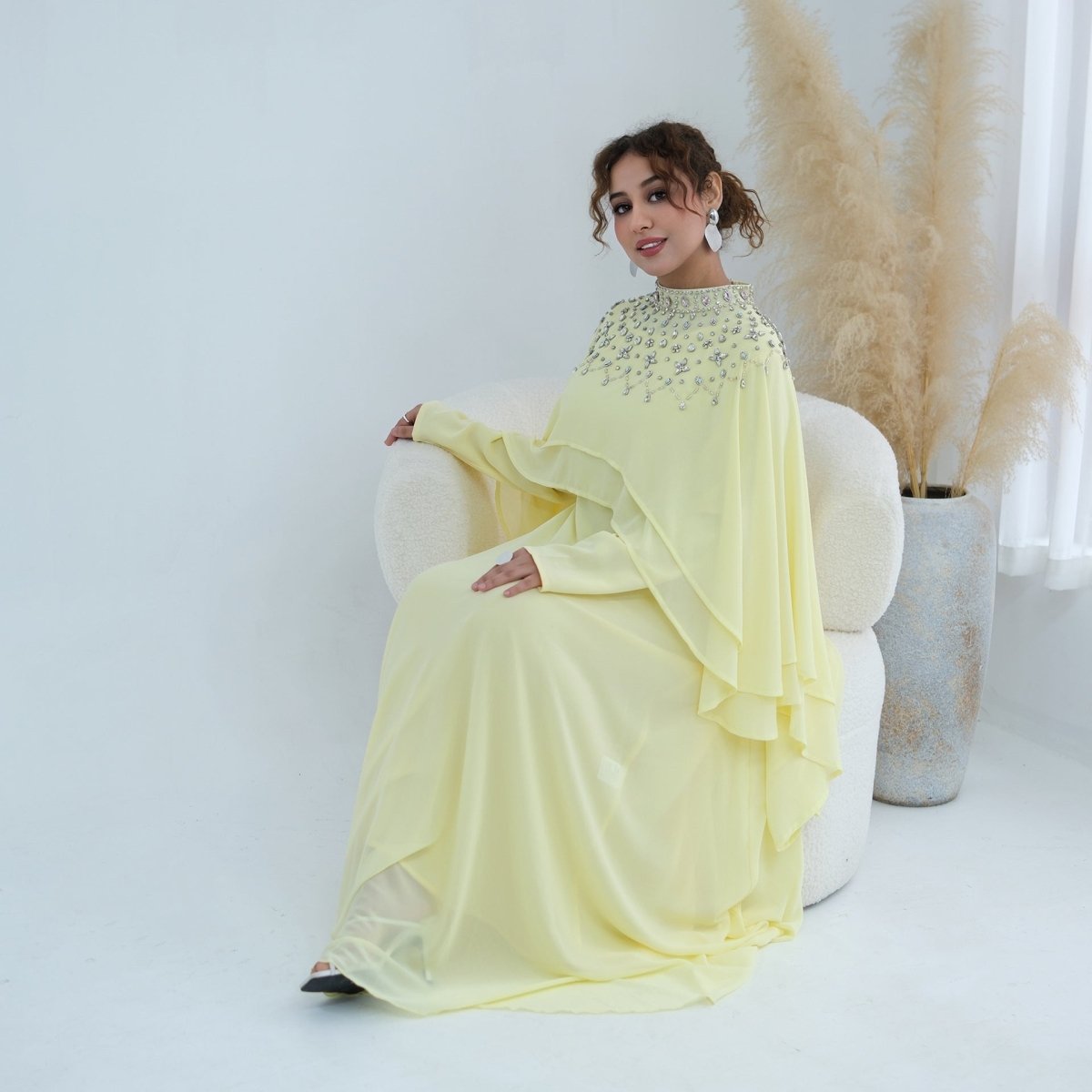 Side view of batwing cape drape over fitted inner sleeve
