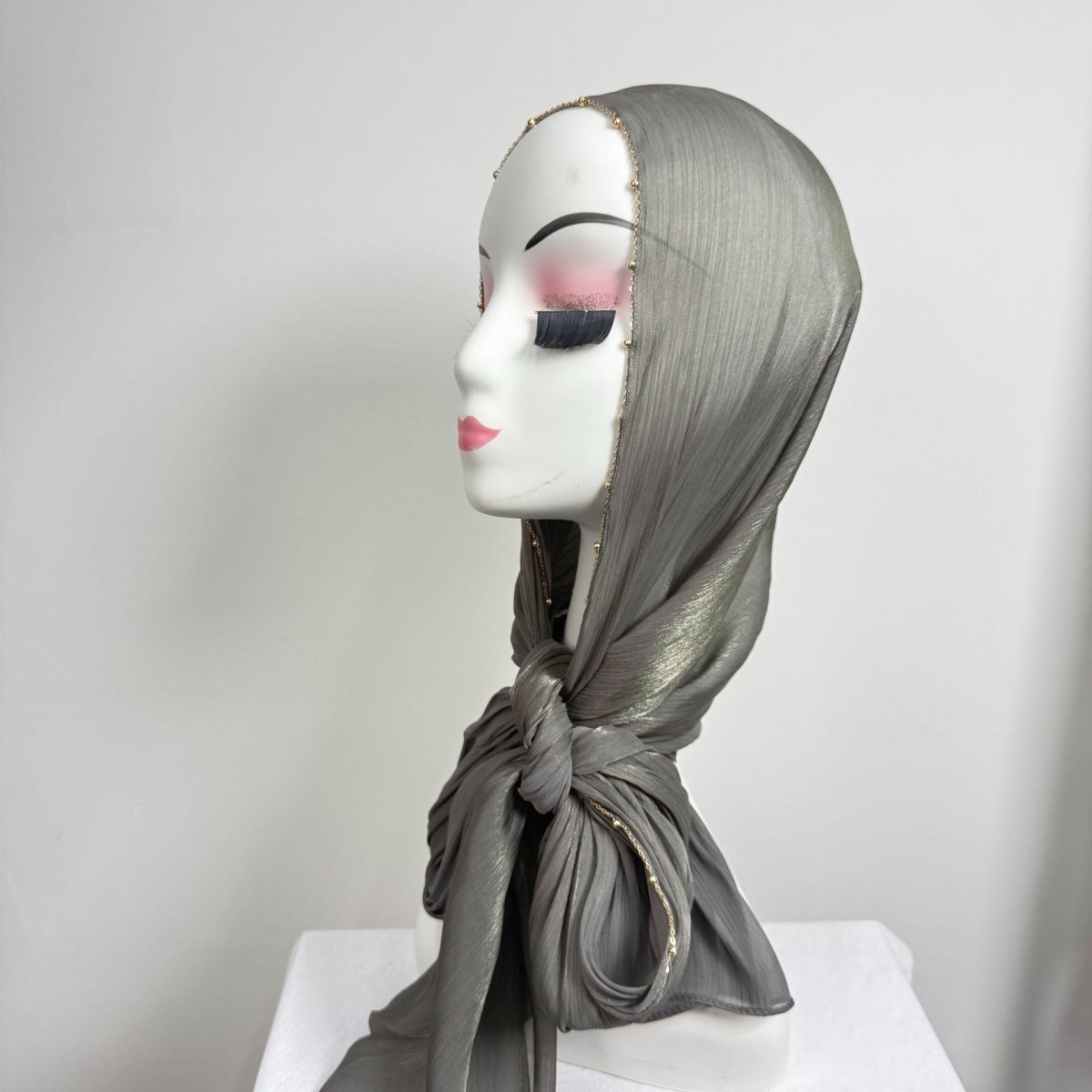 Gold beaded hijab draped as headscarf with chain edge framing the face