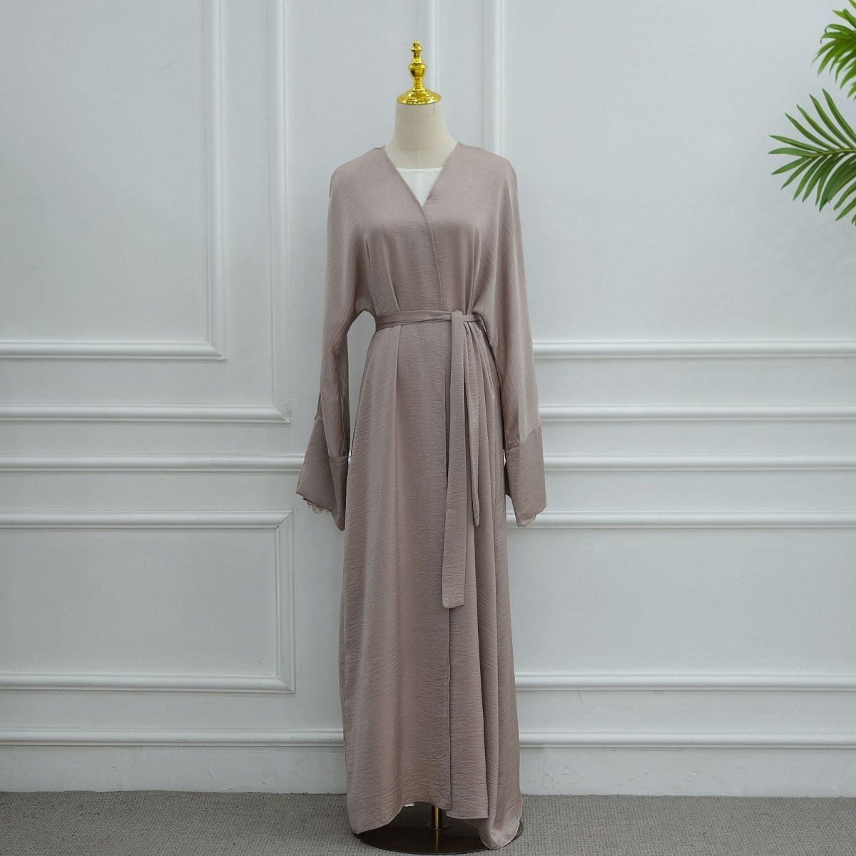 Flat lay of open abaya with matching self-tie belt