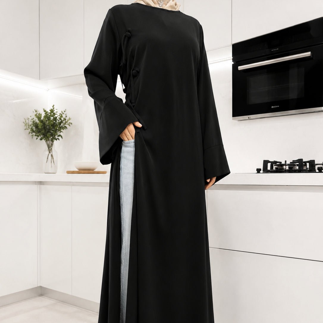 Side view of modest Nida top highlighting high side slit and layering over wide-leg trousers