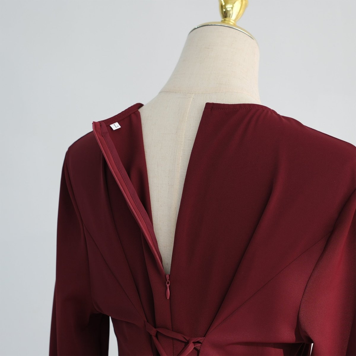 Side profile of full-length nida flared maxi dress showing silhouette