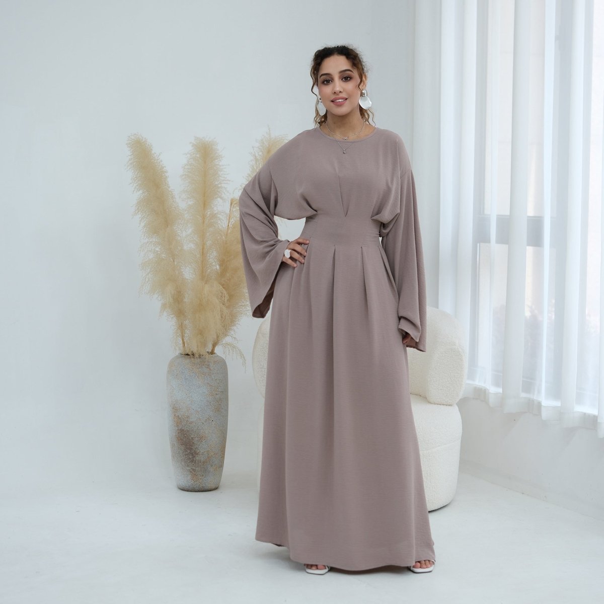Lifestyle view of modest full-length pleated batwing maxi dress
