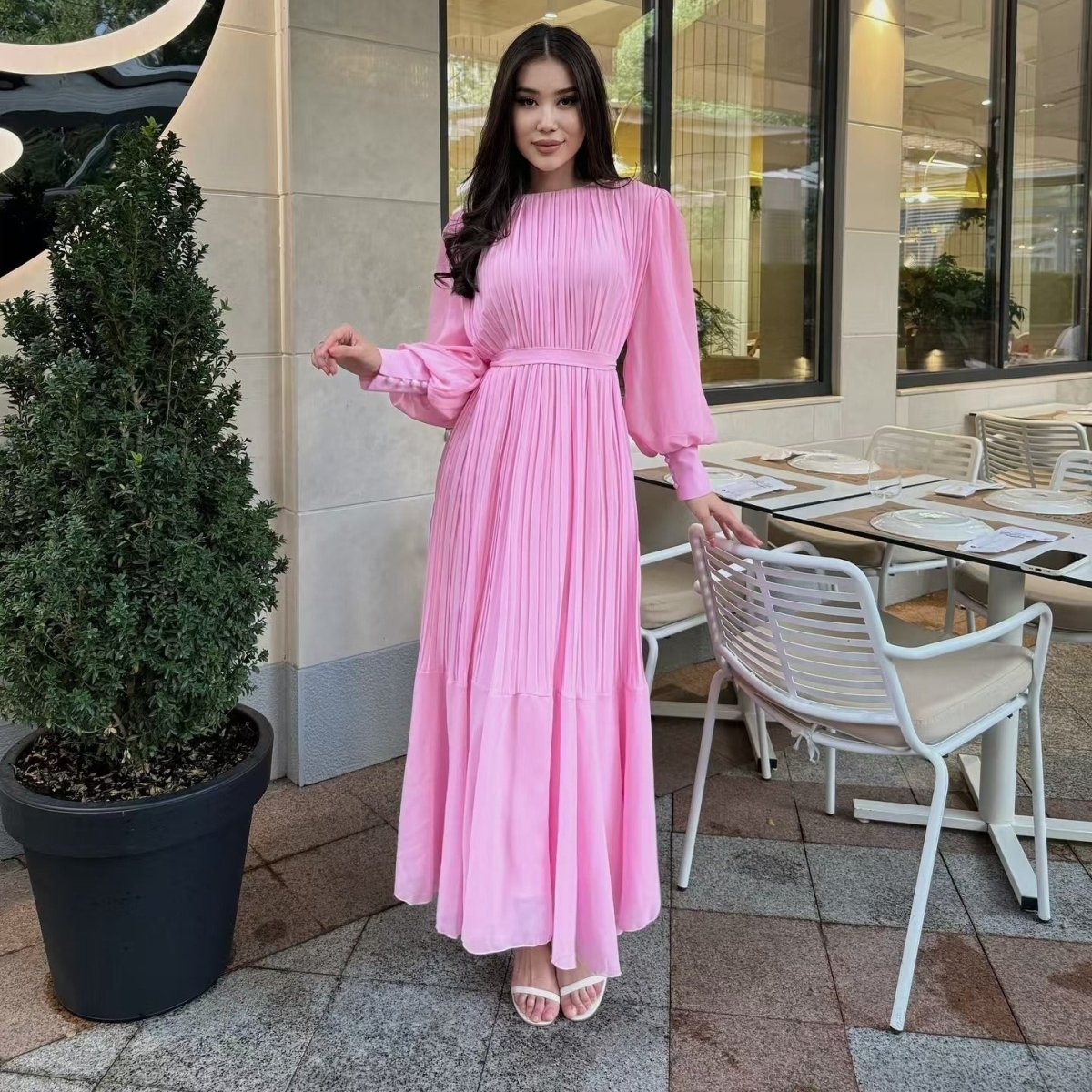 Self-tie belt at waist of pleated maxi dress forming a soft bow