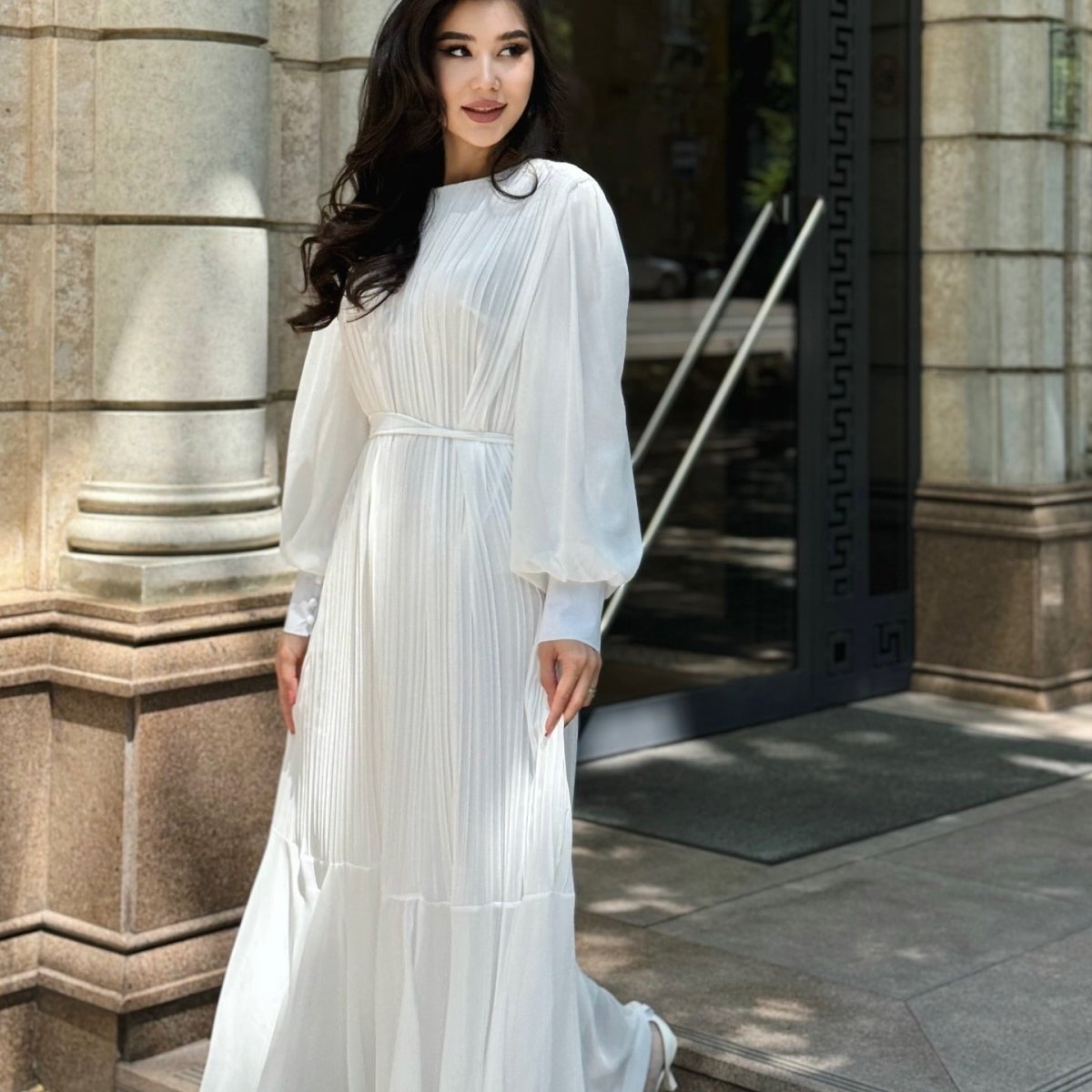 Waist detail showing self-tie belt and loop construction on pleated dress