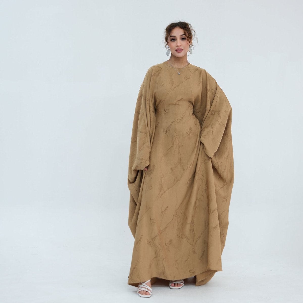 Three-quarter back view of gold print batwing maxi dress with open cuffs