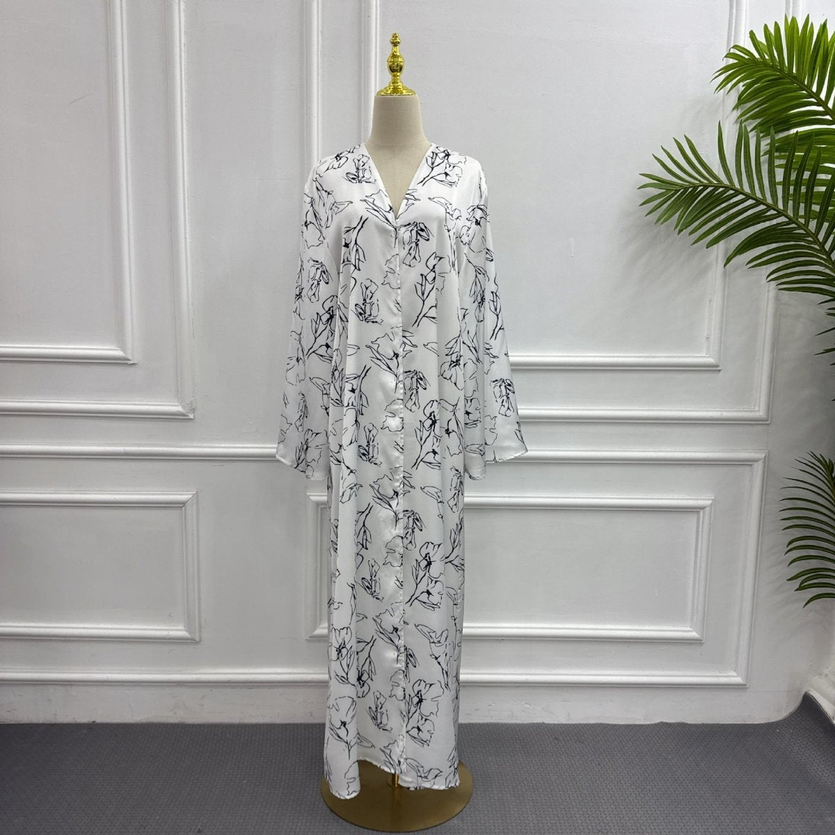 Side profile of printed double-layer abaya showing fluid drape and V-neckline