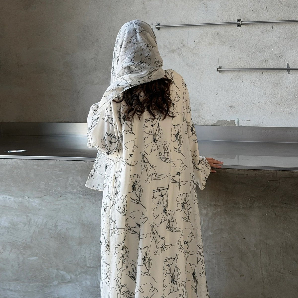 Close-up of concealed silver snap button placket on printed open abaya