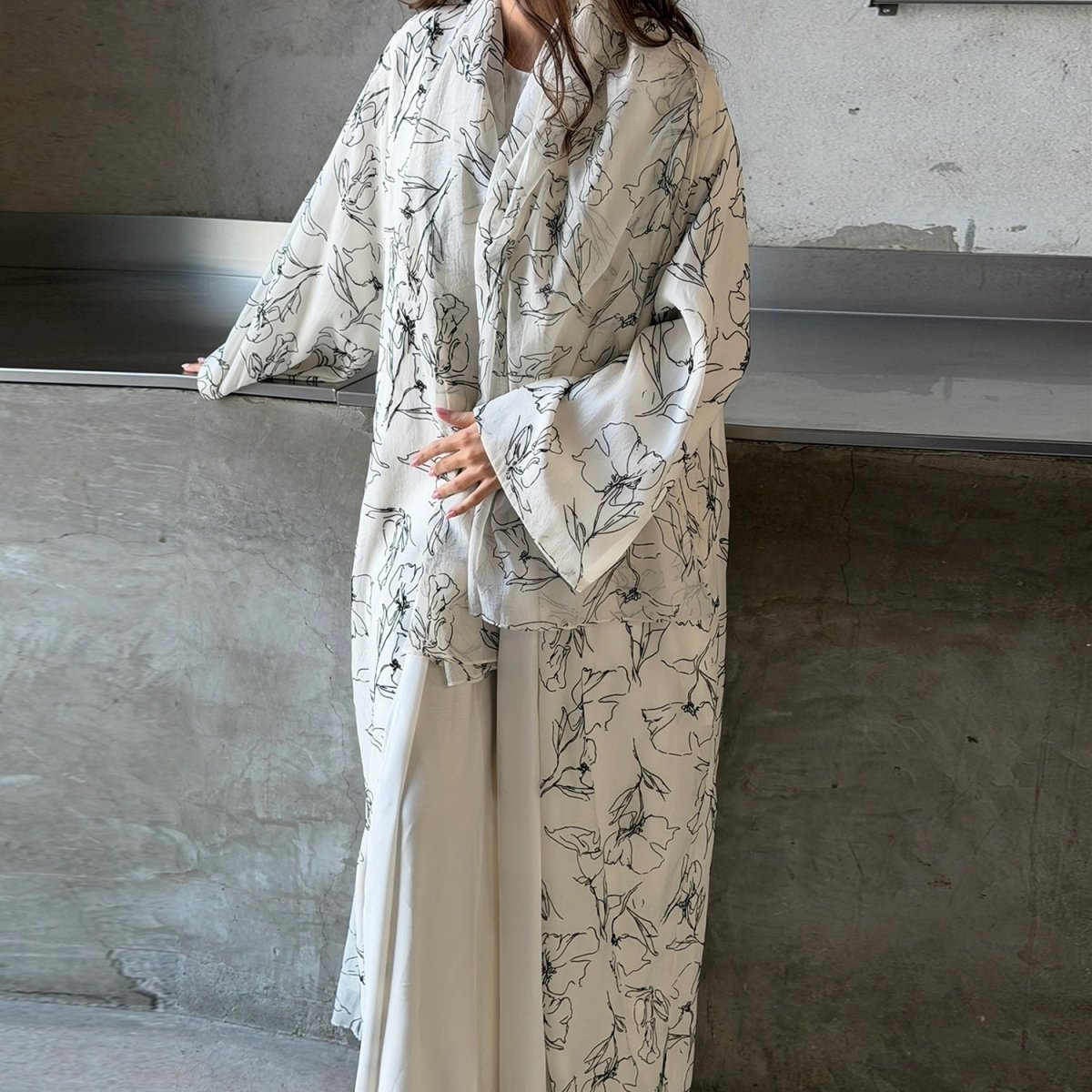 Ink-brush floral print open abaya showing dramatic flared sleeve detail