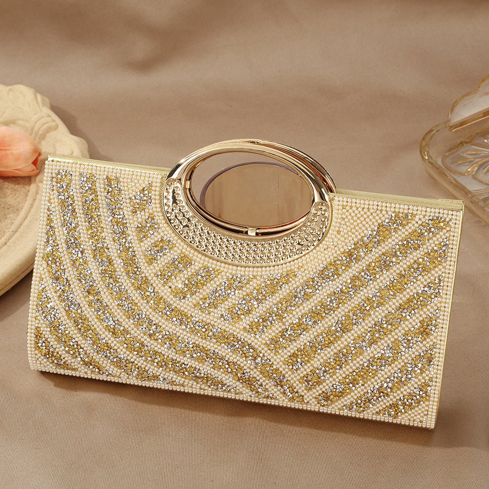 Rhinestone clutch bag in gold hardware finish on marble surface